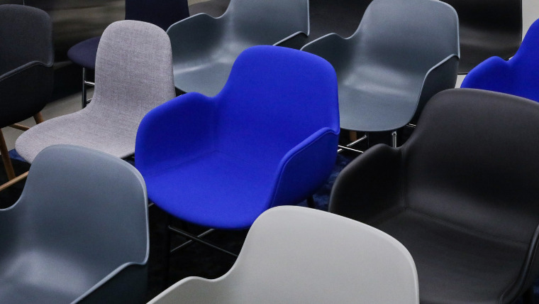 灰色や青色の椅子がいくつも並んでいる写真。