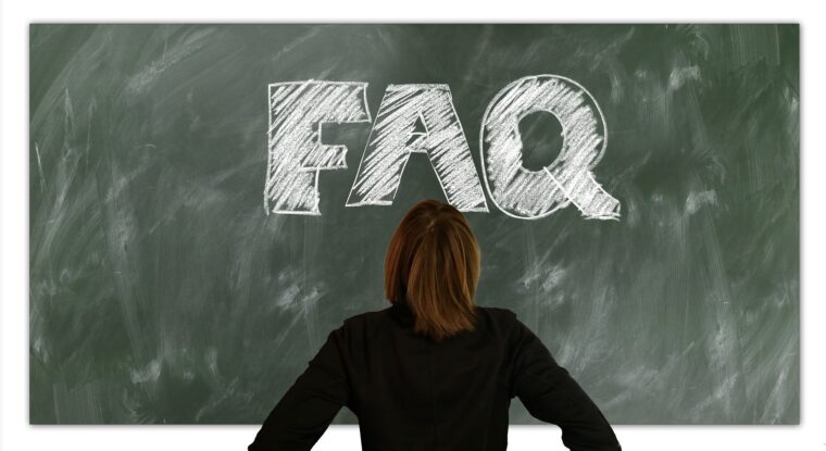 大きな字で「FAQ」と書かれている黒板を真正面から見ている女性の写真。