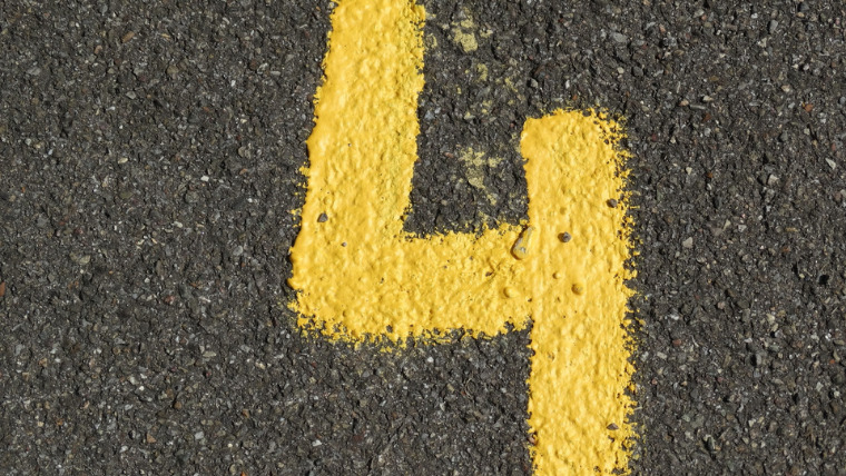 道路に黄色のチョークで「４」と書かれている写真。