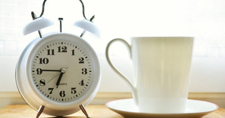 時計とコーヒーカップが並んで写っている写真。